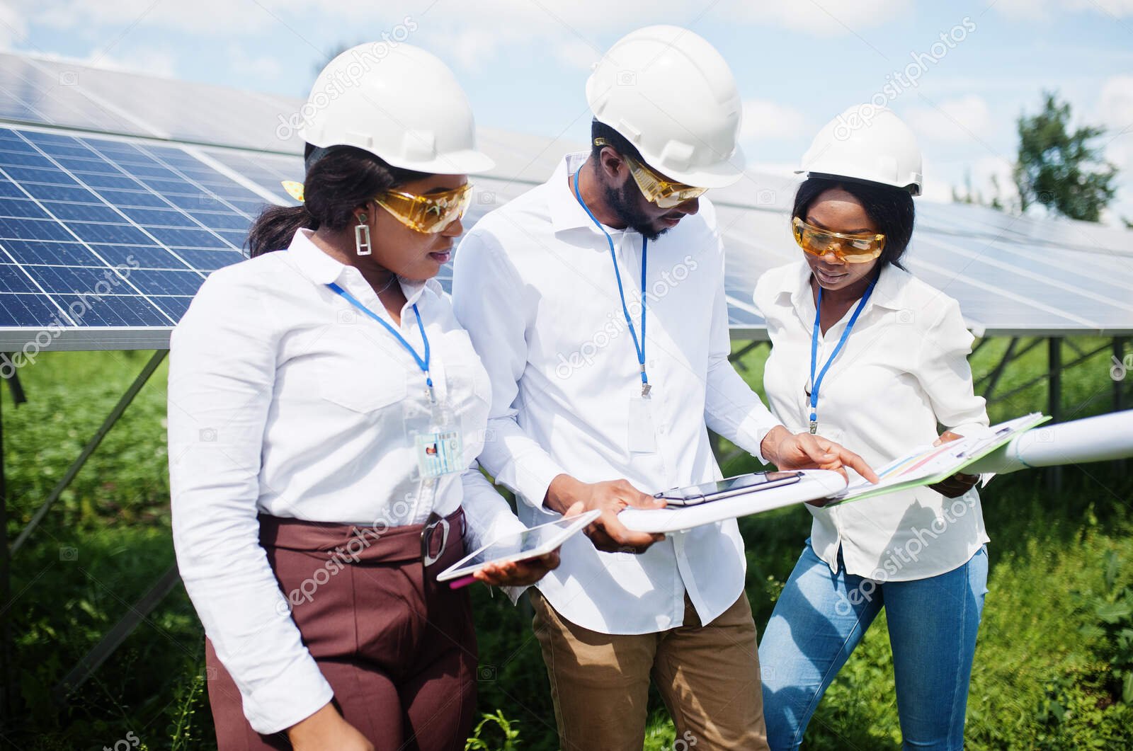 african american technician checks the maintenance of the solar panels. group of three black engineers meeting at solar station.